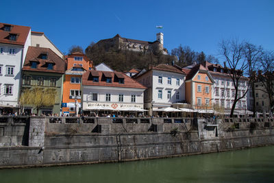 Buildings in city against clear blue sky