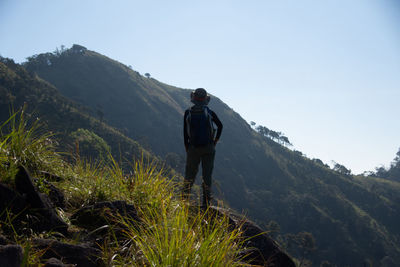 Rear view of man on mountain against sky