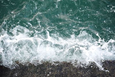 High angle view of waves splashing on rocks