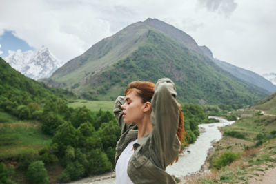 Side view of woman standing on mountain