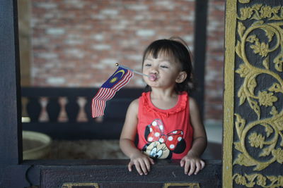 Girl looking away while sitting on wall