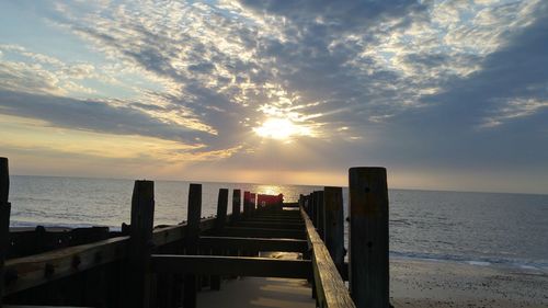 Pier on sea at sunset