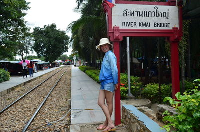 Portrait of woman standing at railroad station platform