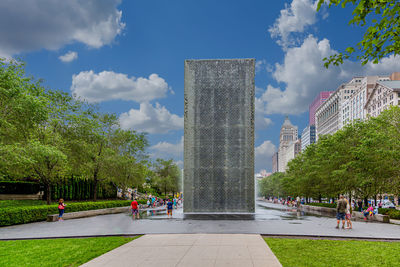 People in city against cloudy sky