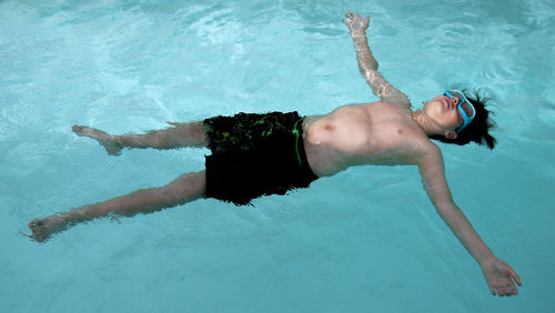 Child floating on water relaxed in the pool. kid recovering energy after school. learning to swim