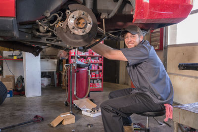 Portrait of mechanic repairing car at workshop