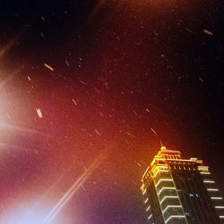 Low angle view of illuminated building against sky at night