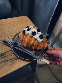 High angle view of person holding bread on table