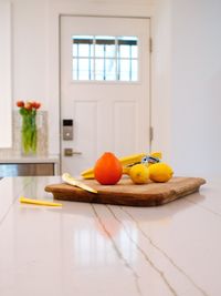 Fruits on cutting board over table at home