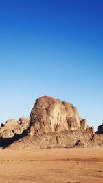 Rock formations in desert against clear blue sky