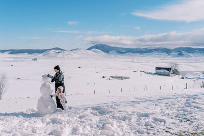 Rear view of man walking on snow covered mountain