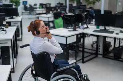 Side view of woman using mobile phone while sitting in gym