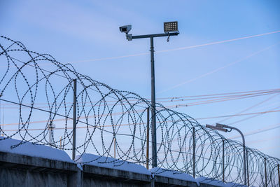 Low angle view of barbed wire against sky