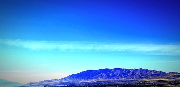 Scenic view of snowcapped mountains against blue sky