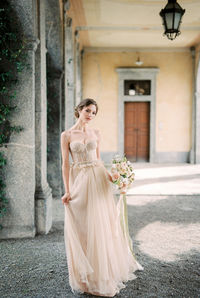 Portrait of young woman standing in city