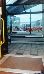 Train at railroad station in city against sky