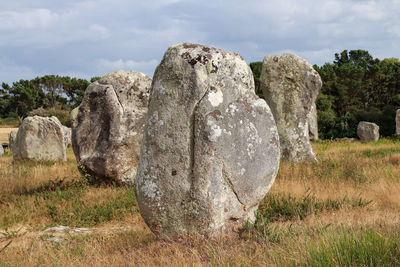 View of rocks on field against sky