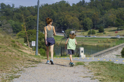 Rear view of woman walking on road