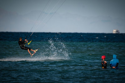 Man kiteboarding over sea against sky