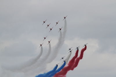 Low angle view of airplanes flying against sky