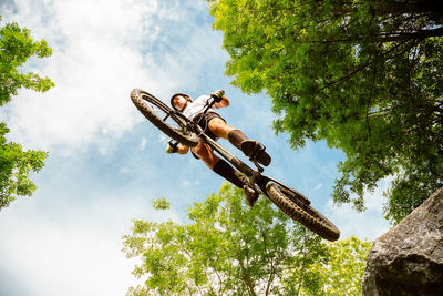 Low angle view of man on tree against sky