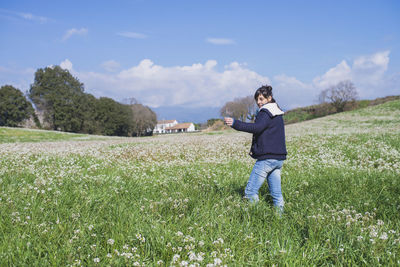 Woman standing on field against sky