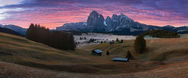 Scenic view of field and mountains against sky during sunset