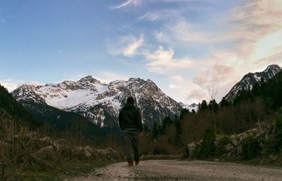 Rear view of man standing on snow covered mountain