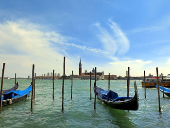 Boats moored on wooden post in water