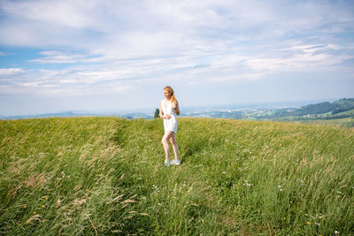 Woman standing on field against sky