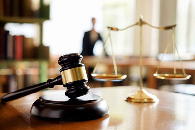 Close-up of gavel and weight scale on table in courtroom