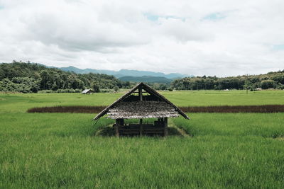 Gazebo on agricultural field against sky