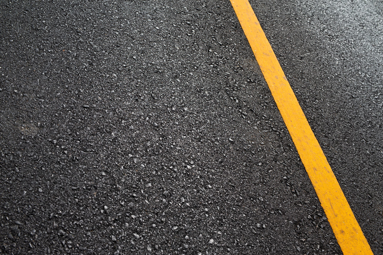 HIGH ANGLE VIEW OF ARROW SYMBOL ON ROAD