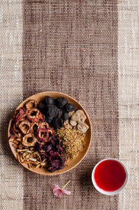 High angle view of potpourri with bowl of aromatic oil on mat