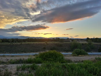 Scenic view of field against sky at sunset