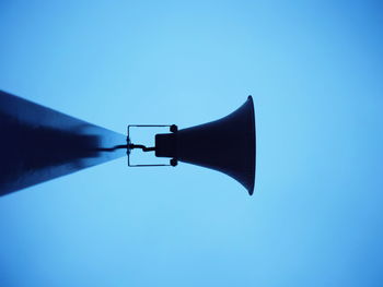 Low angle view of silhouette megaphone against clear sky