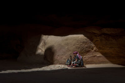 Rear view of people sitting on rock formation