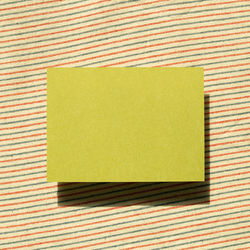 Close-up of yellow paper against colored background