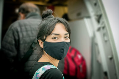 Close-up of young woman traveling wearing mask. 