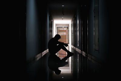 Side view of silhouette woman standing in corridor