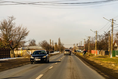 Cars on road against sky in city