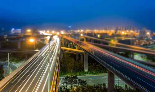 Light trails on road in city against sky at night