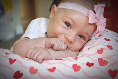 Close-up of cute baby boy lying on bed at home