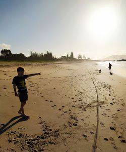 Full length of boy on beach against sky