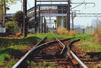 Railroad tracks by trees against sky