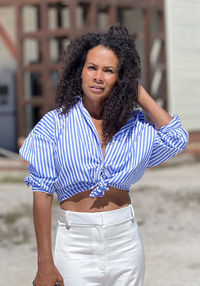 Portrait of young woman standing at beach