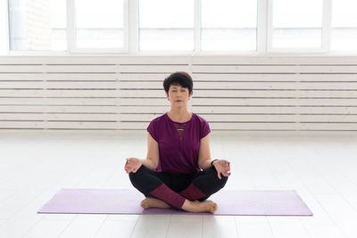 Full length of man sitting on floor