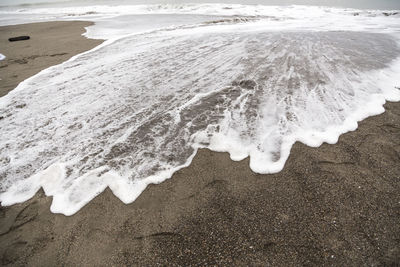 High angle view of surf on shore at beach