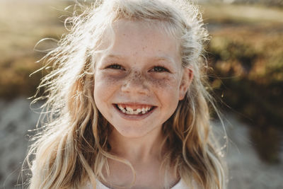 Close up portrait of young school age girl with freckles smiling