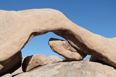 Low angle view of rock formation against clear blue sky